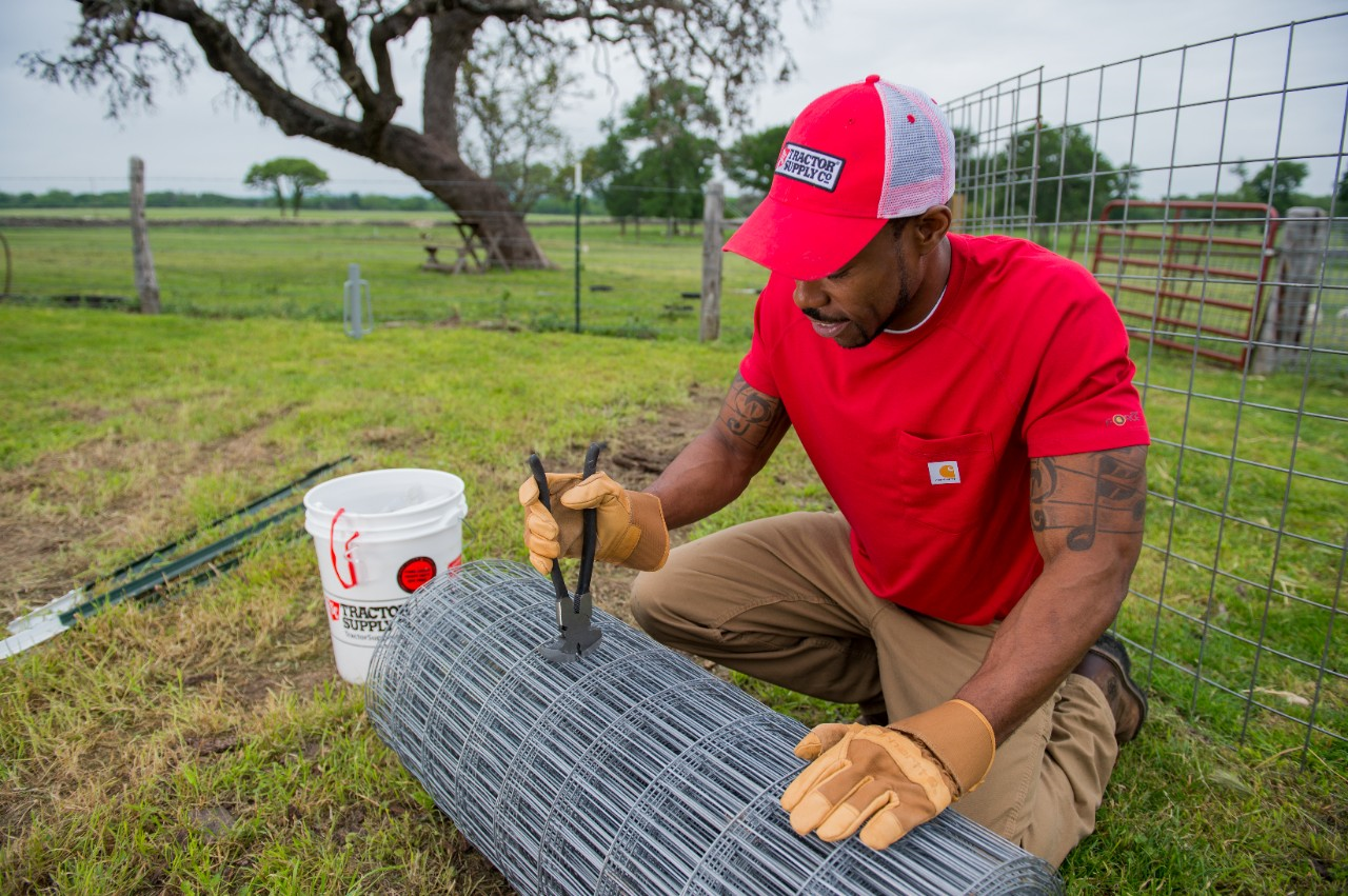 Image of a person using fence pliers on wire fencing.